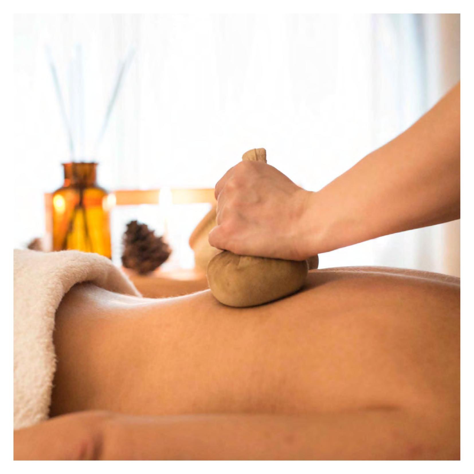 Treatment suite at Spa Faloria — herbal-compress massage with warm bundles of alpine herbs and hay