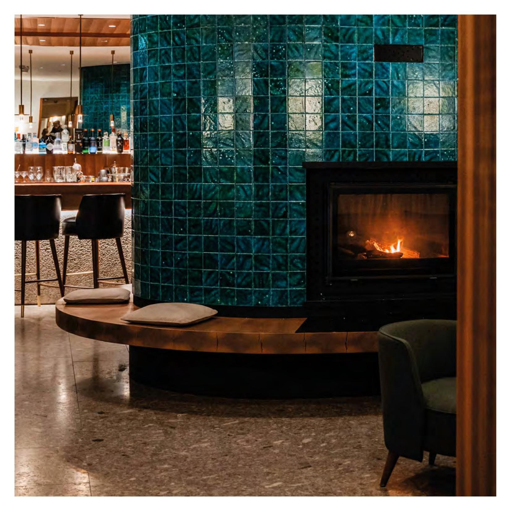 Faloria Lounge Bar — green-tiled fireplace recalling the Ampezzano lakes
