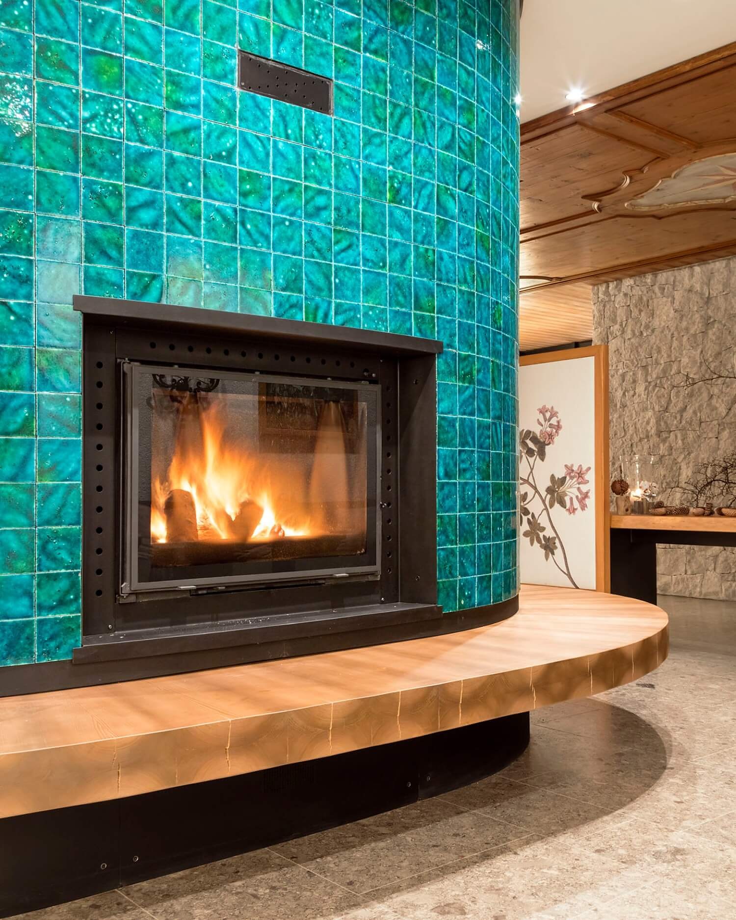 Lounge fireplace at Faloria Mountain Spa Resort — turquoise tile column designed by Flaviano Capriotti